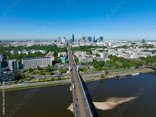 widok z lotu ptaka z drona na centrum Warszawy i most Poniatowskiego, Wisła, dużo zieleni i niebieskie niebo