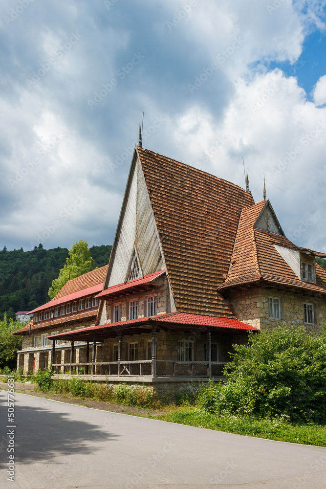An old mountain house on the background of a picturesque sky with clouds