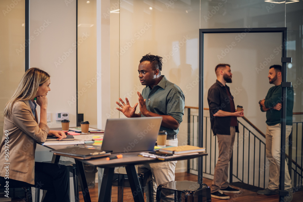 Two multiracial business colleagues working together in the office Two multiracial business colleagues working together in the office