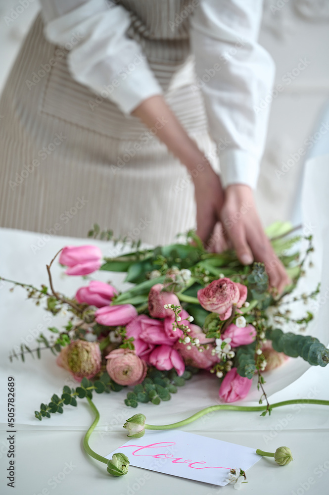 Young creative woman in a flower shop, using laptop. A startup of florist business. Young creative woman in a flower shop, using laptop. A startup of florist business.
