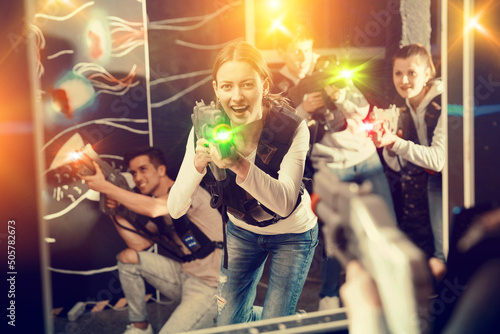 Smiling girl with laser guns took aim and having fun with friends. High quality photo
