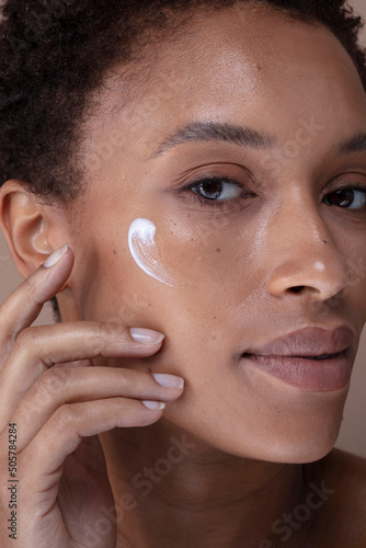 Close-up of woman applying moisturizer on face