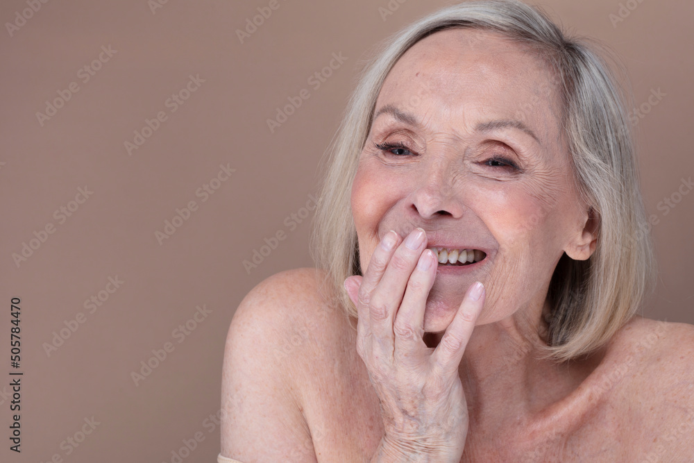 Studio shot of senior woman laughing