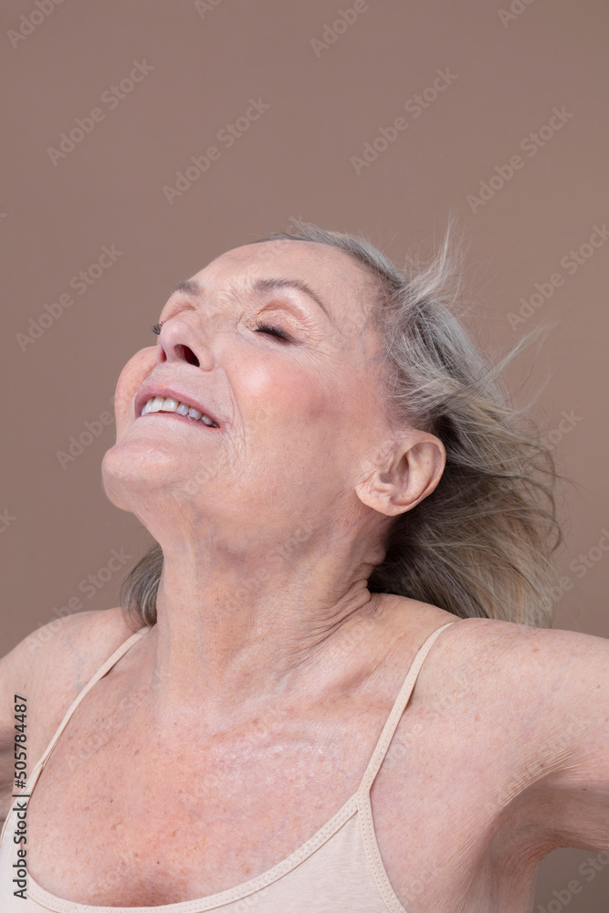 Studio shot of smiling senior woman with windswept hair Studio shot of smiling senior woman with windswept hair