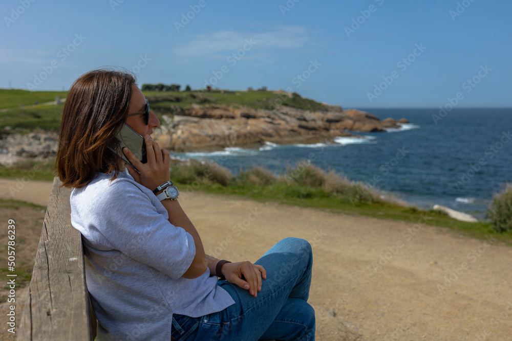 Talking on the phone near the ocean. Talking on the phone near the ocean.