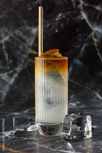 Obraz na płótnie Dark n Stormy cocktail standing on the black marble background. Refreshing Boozy Rum Dark and Stormy Cocktail with Ginger Beer. w salonie
