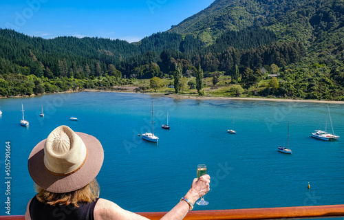 woman toasts New Zealand inlet from cruise ship