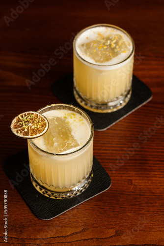 Obraz na płótnie Warm colored cocktails. Mezcal cocktail and Alcoholic Scotch Whiskey Penicillin Drink Cocktail. Cocktail glass on bar counter w salonie