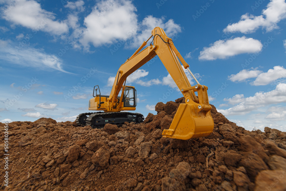 Selective focus with Bucket ,Excavator are digging soil in the construction site on sky background,with white fluffy cloud Selective focus with Bucket ,Excavator are digging soil in the construction site on sky background,with white fluffy cloud