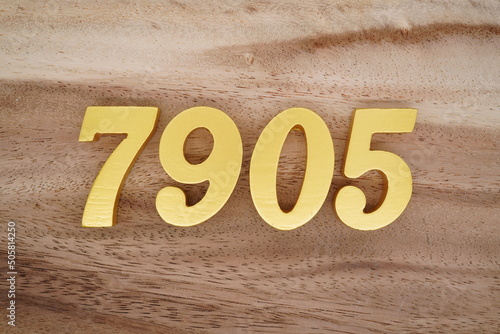 Number 7905 is made of 1 cm thick teak, painted gold on top of real wood with dark brown to light brown patterns to show the dimensions of the picture. photo