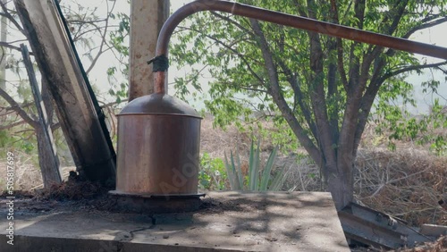 a master mezcalero distilling mezcal in oaxaca photo