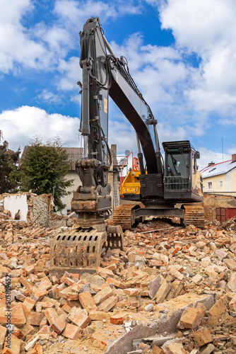 Bagger auf den Tr  mmern eines abgerissenen Geb  udes