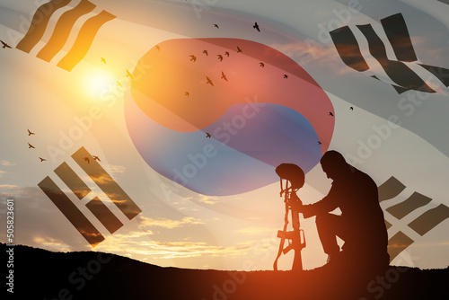 Silhouette of soldier kneeling with his head bowed against the sunrise or sunset and South Korea flag. Concept - armed forces of Korea. Greeting card for Memorial Day, Liberation Day. 3D-render. photo