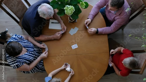 Big Happy Family with kids playing cards at the table together, hobby, leausure. View from above photo