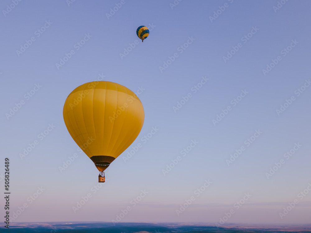 Fototapeta premium view of air balloon with basket flies on sunset
