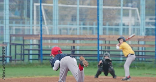 Slow motion, baseball tournament at school, boys play baseball, the pitcher throws the ball toward a batter, batter successfully hits a fastball.