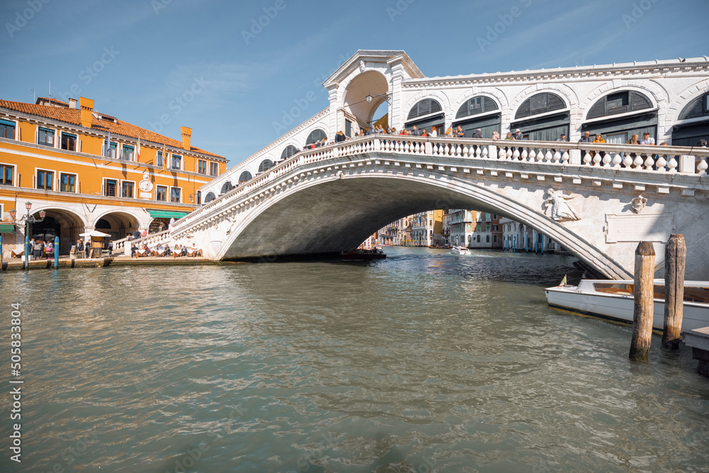 View on Grand Canal with famous Rialto bridge in Venice. Italian landmarks and traveling Italy concept. Cityscape in autumn sunny day