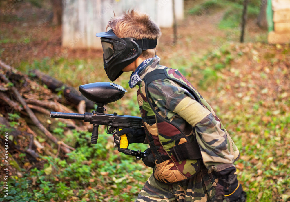children playing paintball in the forest children playing paintball in the forest