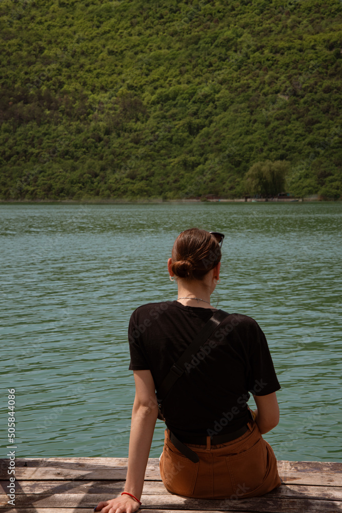 Fototapeta premium Young beautiful woman on the background of a cypress lake. Girl traveler.