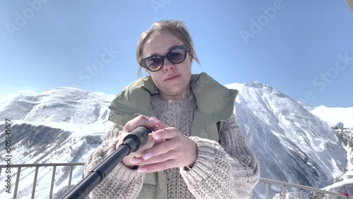 young beautiful girl  in the mountains is recording selfie video