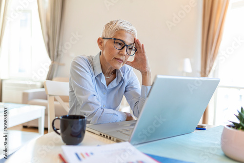 Mature business woman concerned thinking about online problem.Frustrated worried senior middle aged female suffering from memory loss