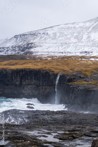 beautiful landscape with mountains, snow, waterfall and sea in Eidi - Faroe Islands