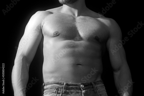 Strong bodybuilder with six pack, perfect abs, shoulders, biceps, triceps and chest, deltoid muscle.