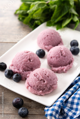 Blueberry ice cream scoops on wooden table