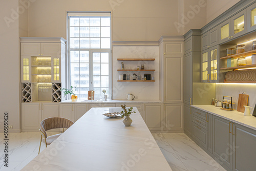 the latest fashion home trends in an ultra modern elegant interior of a cozy studio in soft pastel colors. close-ups of a stylish kitchen with an island for cooking photo