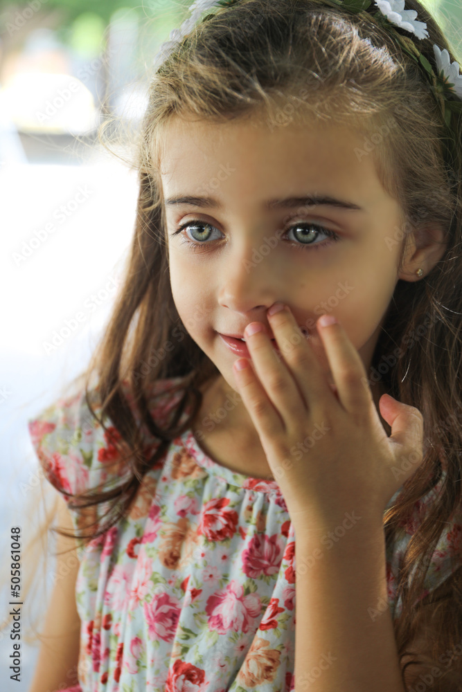 a beautiful girl with brown hair and light green eyes, wearing a flowery dress, happy and smiling in the city of Alicante, Spain. a beautiful girl with brown hair and light green eyes, wearing a flowery dress, happy and smiling in the city of Alicante, Spain.