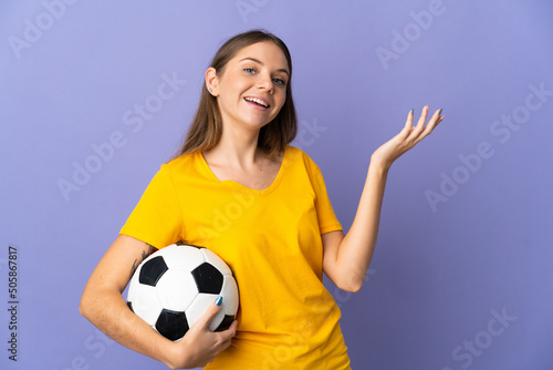 Young Lithuanian football player woman isolated on purple background extending hands to the side for inviting to come © luismolinero
