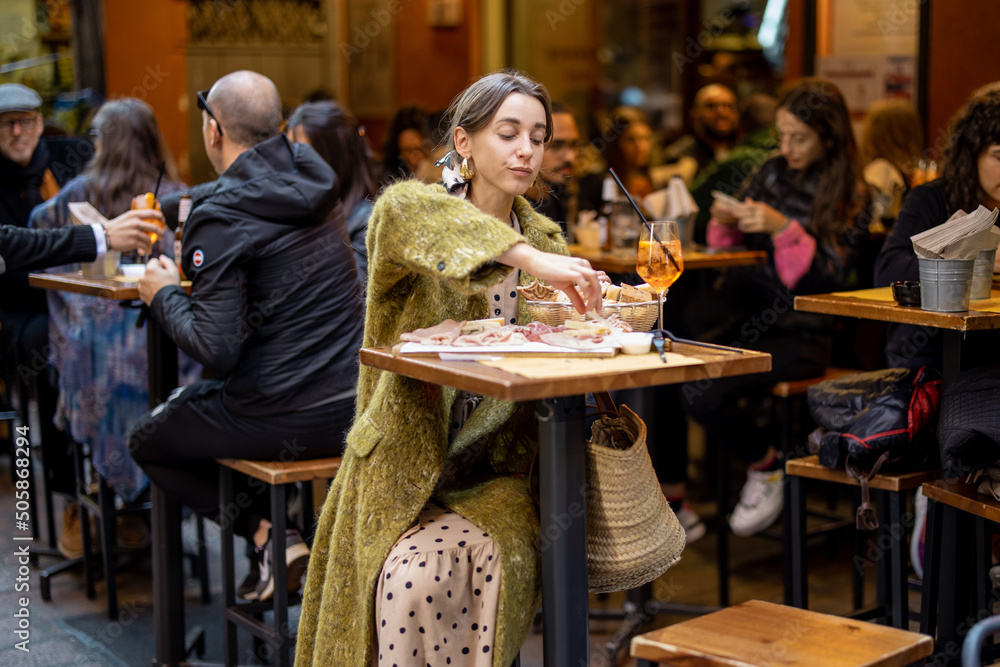 Φωτογραφία Woman sitting on crowded street at bar or restaurant outdoors in Bologna city