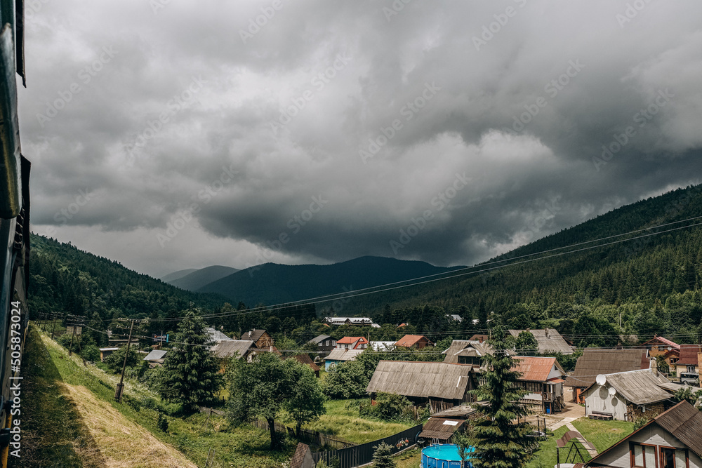 Fototapeta premium Travel to the mountains by train in summer. Beautiful scenery from the train window.