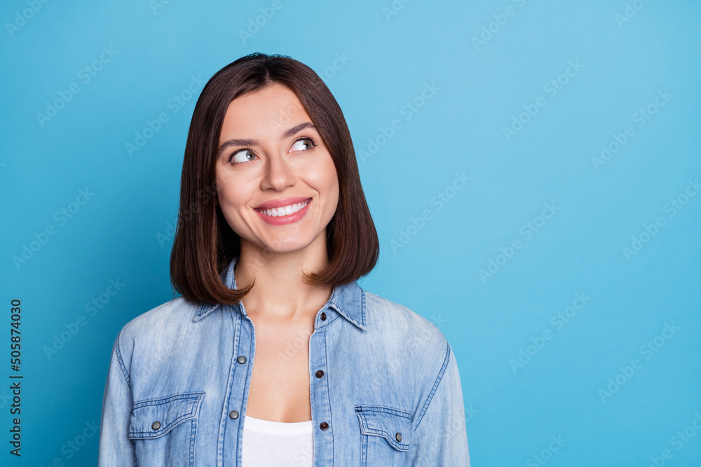 Photo of positive minded girl toothy smile look interested empty space isolated on blue color background Photo of positive minded girl toothy smile look interested empty space isolated on blue color background