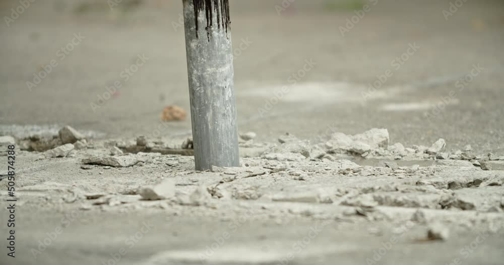 Close-up of excavator hydraulic arm rock breaker working on concrete road.hydrauric hammer destruction concrete floor.4K Prores, 30 fps with sound Close-up of excavator hydraulic arm rock breaker working on concrete road.hydrauric hammer destruction concrete floor.4K Prores, 30 fps with sound