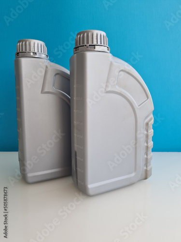 Bottle with motor oil on blue background photo