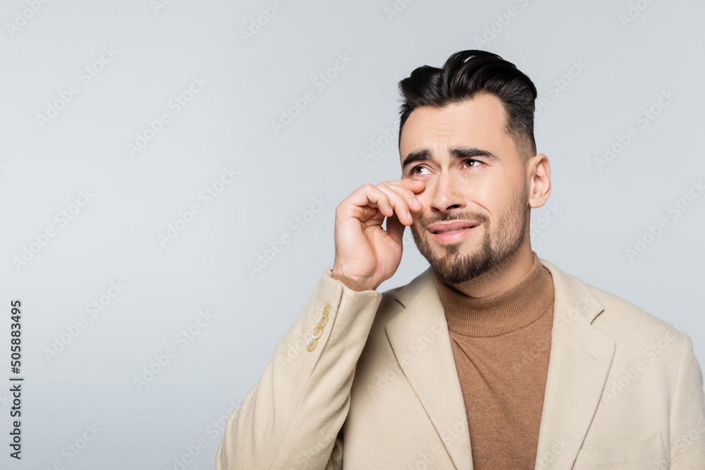 stressed critic looking away and crying isolated on grey. stressed critic looking away and crying isolated on grey.