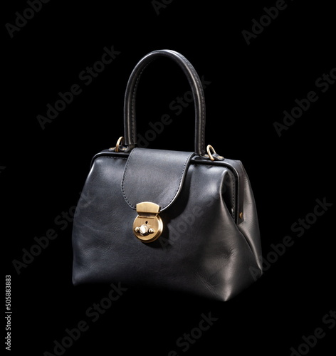 Black classic leather bag on a black background