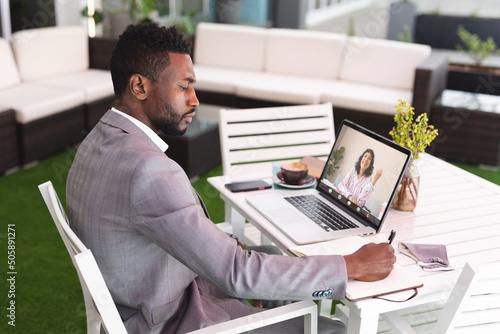 African american businessman discussing strategies with female colleague through video conference