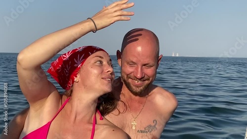 Sea cruise on sailboat. Happy young couple of tourists sail and smile, summer vacation on sailing boat. Close-up on background of sea. Woman and man enjoy water trip. Water Sports lifestyle. photo
