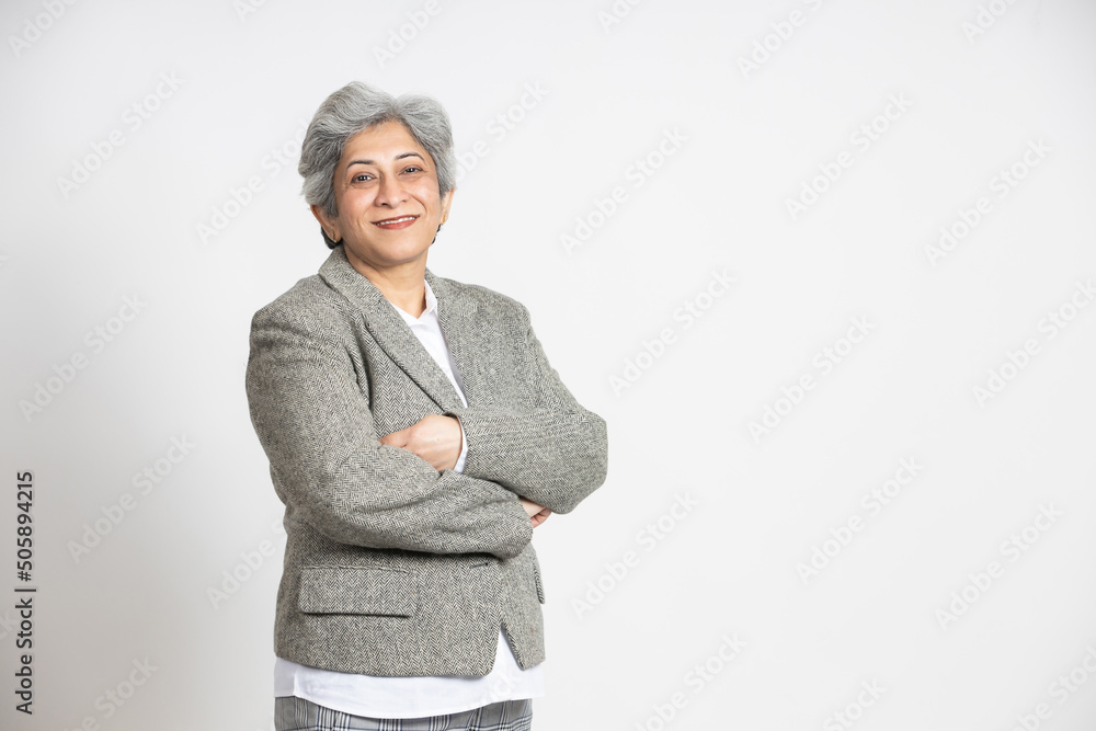 Φωτογραφία Confident mature senior indian businesswoman in a suit standing with his arms cross, isolated on white background