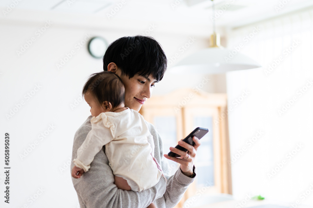 Fotografie 育児についてスマホで調べる男性
