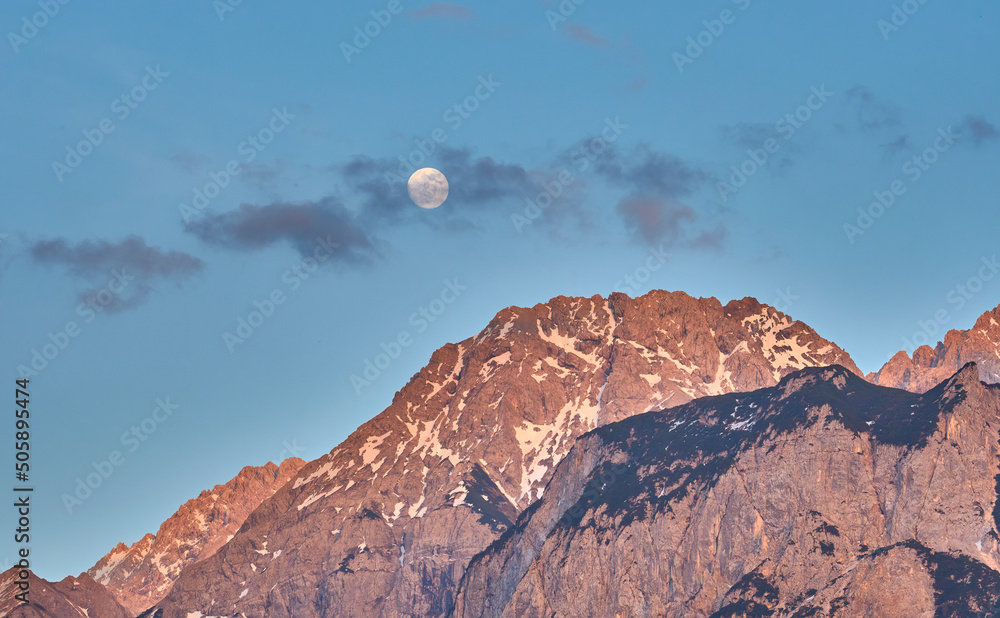Full moon rises over the steep summits of Wetterstein mountain range high above Ehrwald in Tirol Austria, Landscape