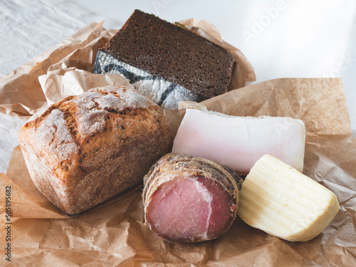Delicious regional products on the craft paper. Wheat and rye bread, cheese and meat