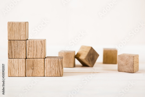 Collapsed stair structure of wooden cubes, business risk due to crisis or unsustainable financial concept. photo