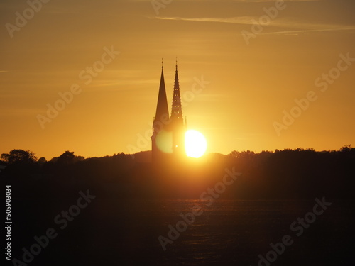 Sunset behind the Douvres-la-Délivrande church in Normandy, France