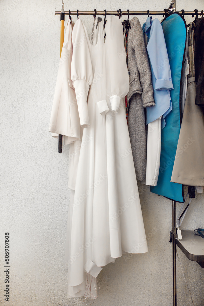 Different dresses hang on rail in the atelier Different dresses hang on rail in the atelier