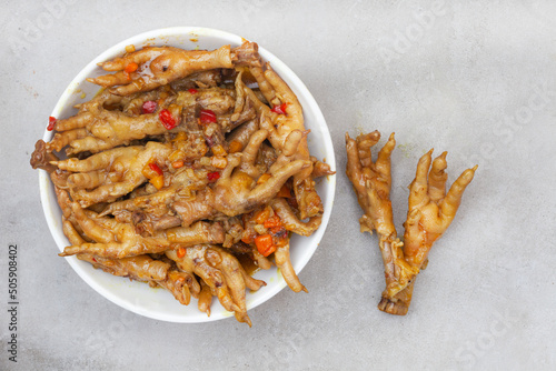 
South African township delicacy, cooked chicken feet or walkie talkies with onion and sauce
 photo