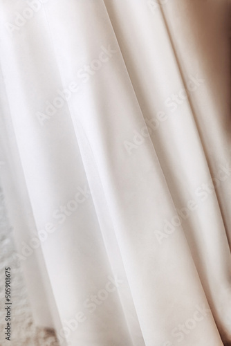 white wedding chiffon half-sewn dresses close-up, fabric texture with waves