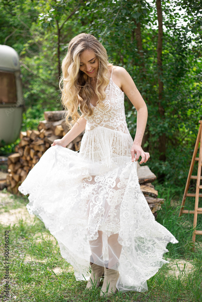Fototapeta premium A bride on a ranch in a white dress and boots